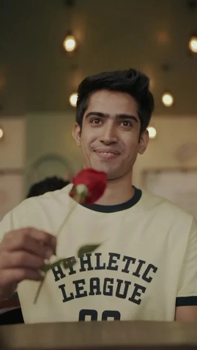 A young man holding a red rose