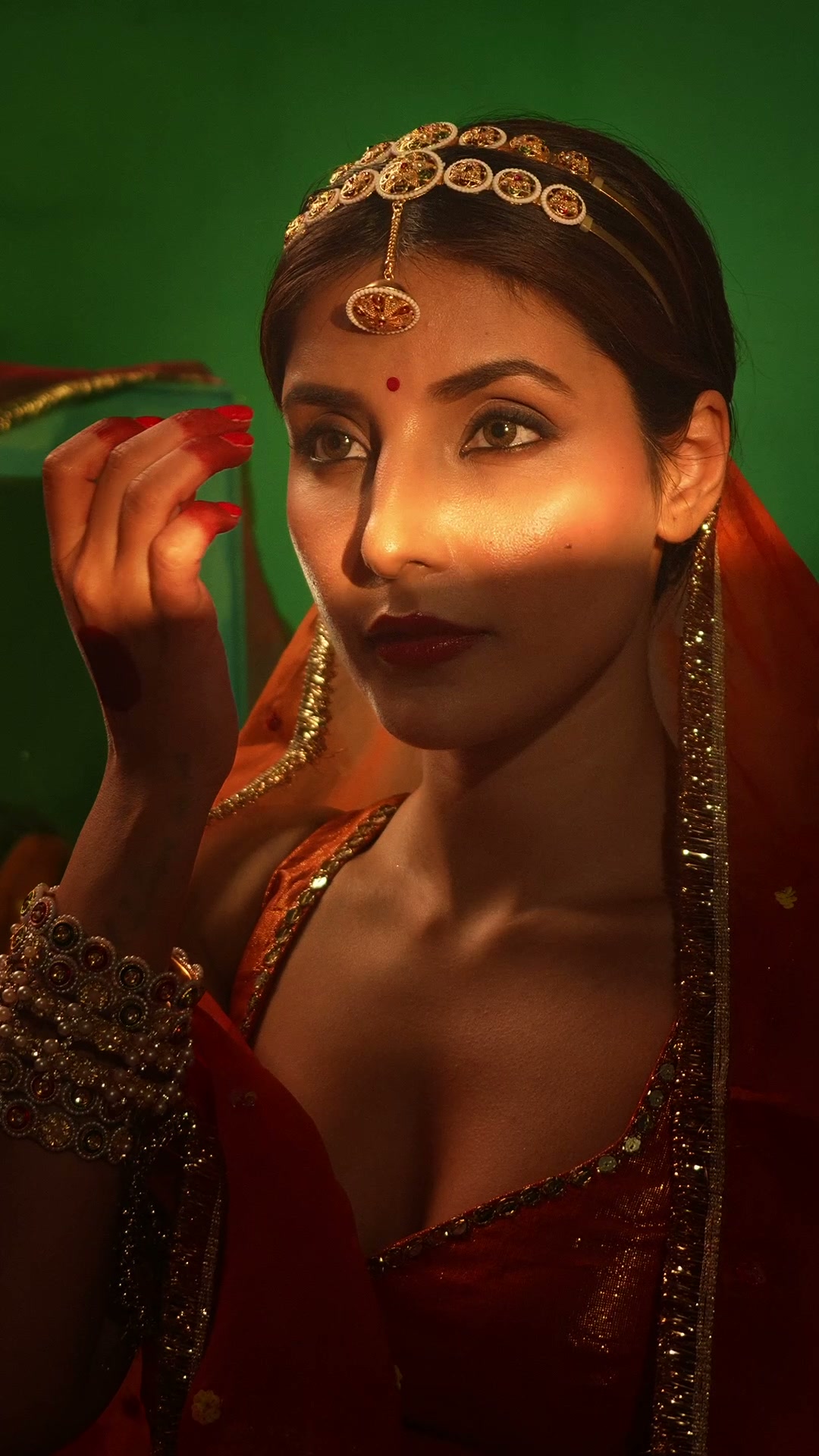 Close-up, hand at her face in a shaft of light