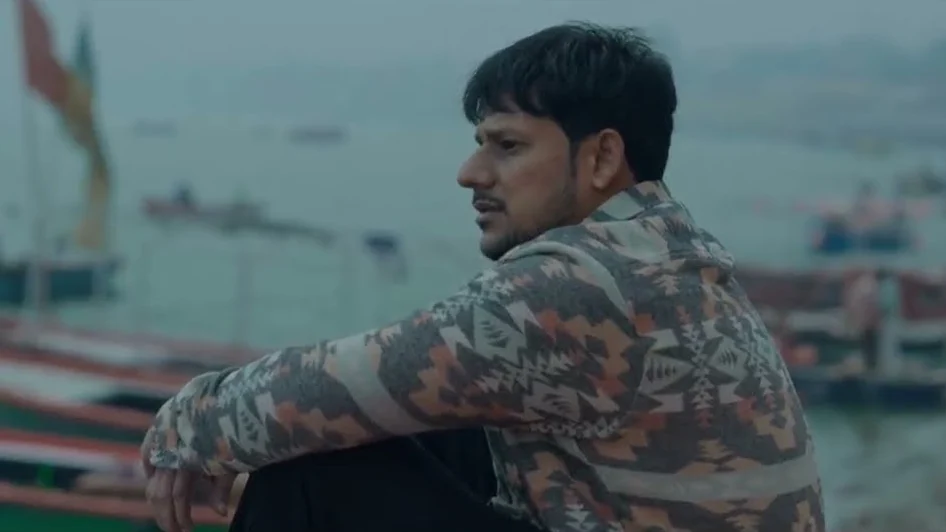 Man sitting by the boats on the ghats