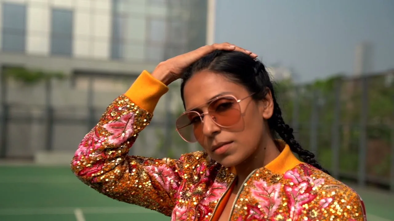 Model in a sequinned jacket and sunglasses