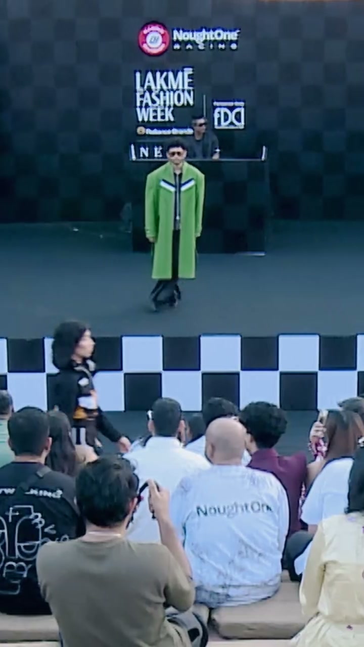 Wide of the chequered runway, green coat at the head