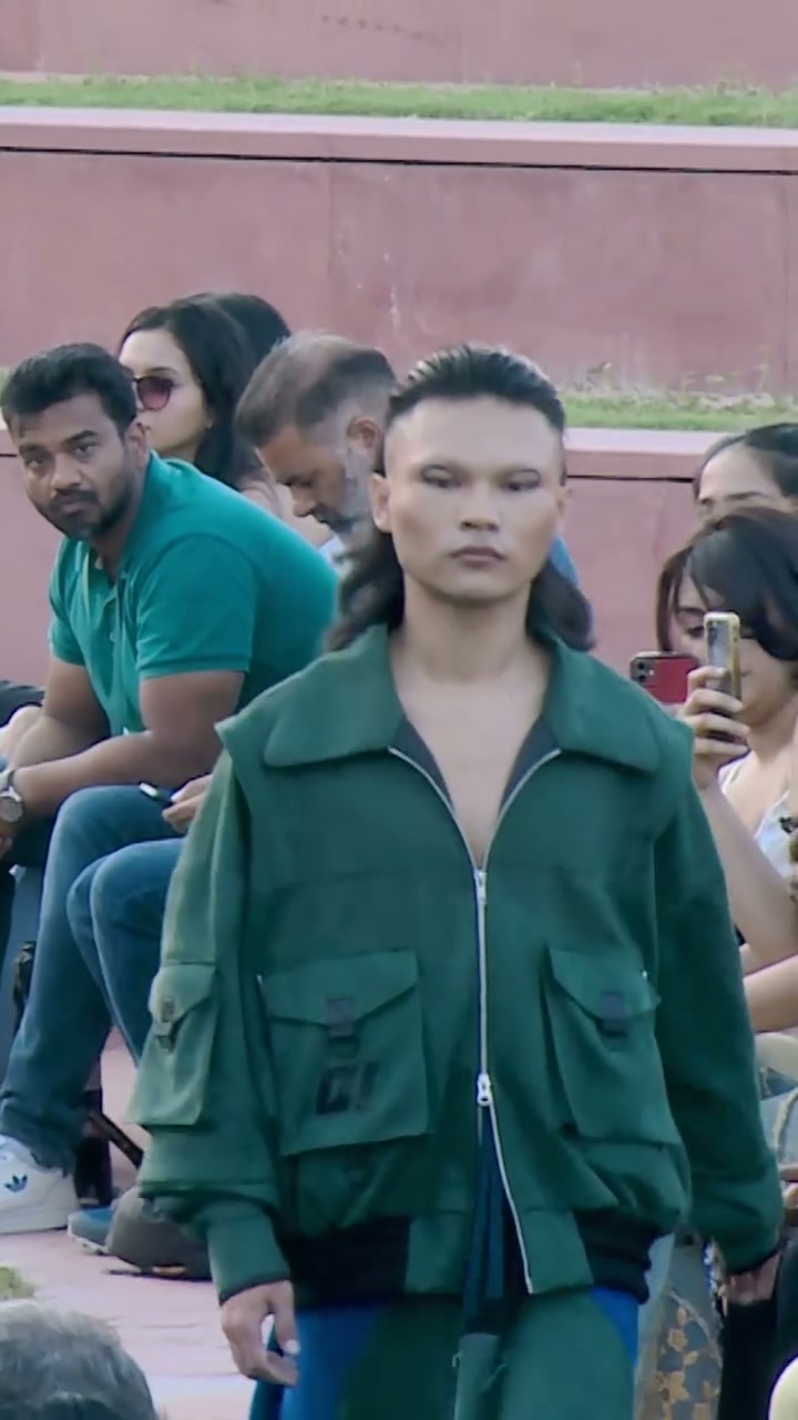 Model in a green bomber, audience behind