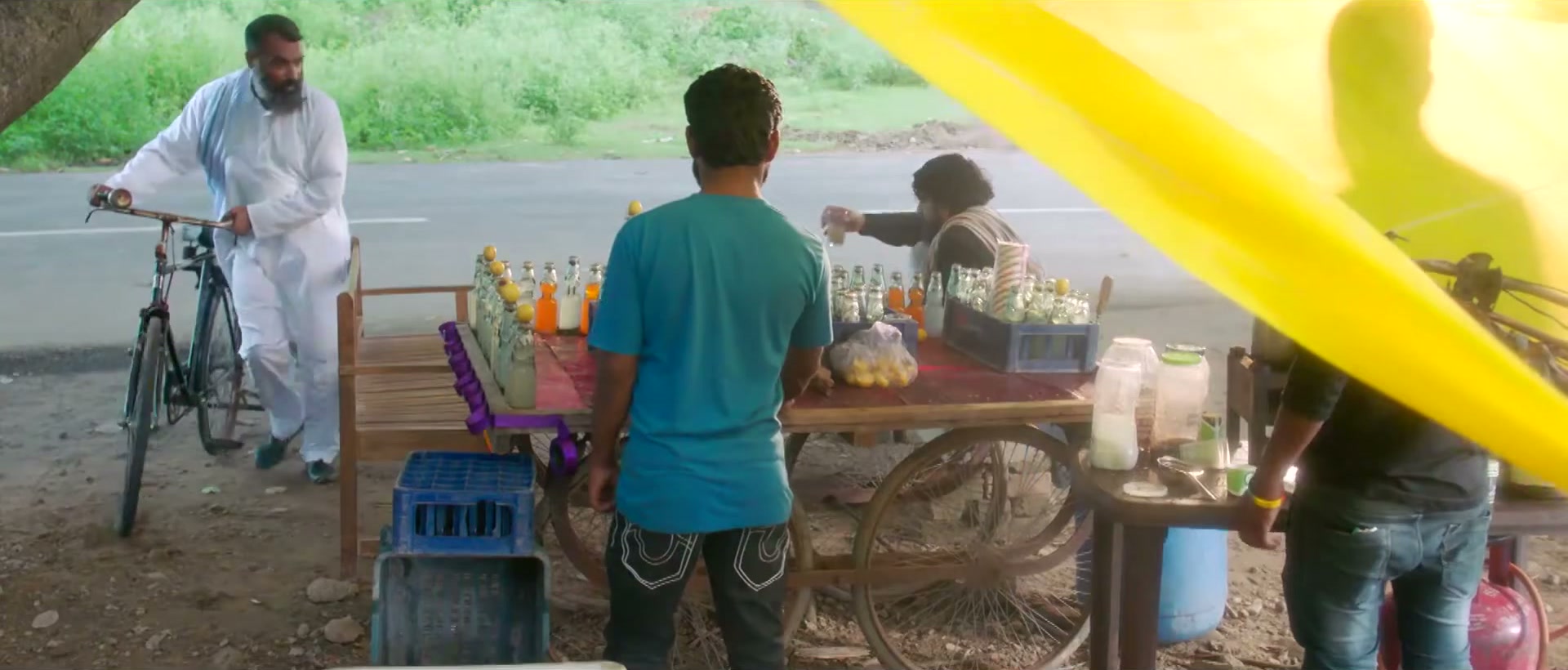 Wide of the roadside drinks stall, man arriving by bicycle