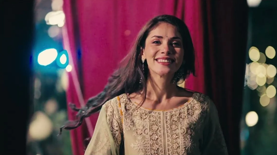A woman smiling in front of a red curtain