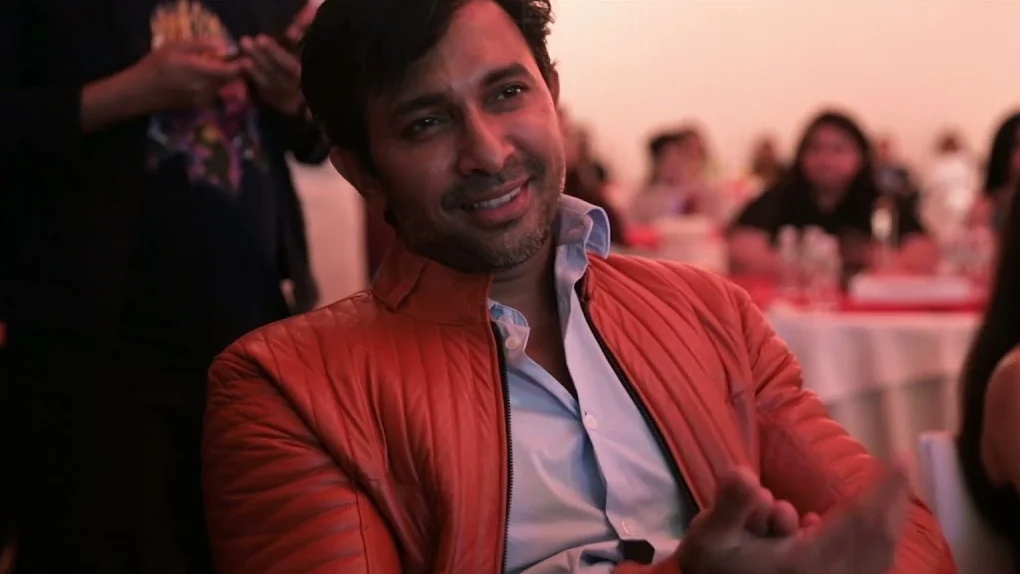 A guest in a red jacket, laughing