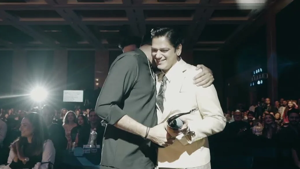 An embrace on stage in front of the audience